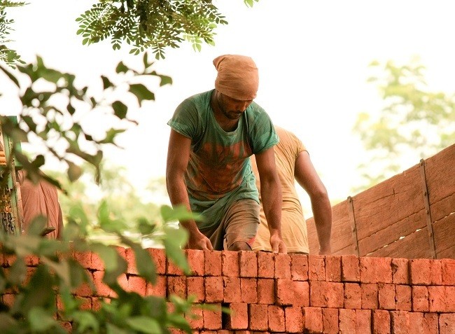 worker building brick wall